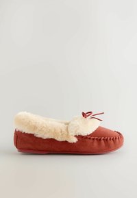 Rustfarvet hjemmesko lavet af ruskind med en fluffy, cremefarvet faux fur foret, dekorativ læderbue og synlige detaljer langs kanterne.