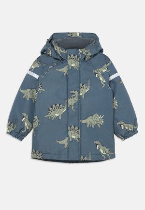 Giacca impermeabile blu con motivi di dinosauri. Presenta un cappuccio, polsini elastici e un accento riflettente sulla manica. Fodera interna morbida.