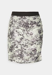Jupe froncée présentant un motif floral argent et noir sur un fond clair, dotée d'une taille noire et d'un tissu lisse et texturé.