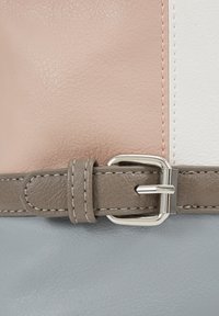 Borsa a blocchi di colore con pelle testurizzata rosa pallido, bianca e grigia. Presenta una tracolla grigia con una fibbia argentata e cuciture a contrasto.