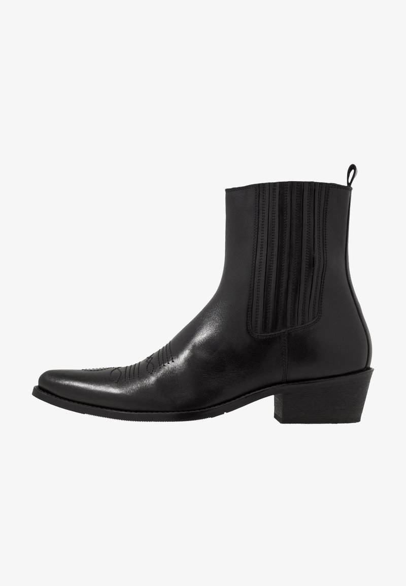 Schwarze Leder- ankle boot mit spitzem Zehenbereich, elastischen Seitenpaneelen, vertikalen Steppnähten und einem niedrigen Blockabsatz.