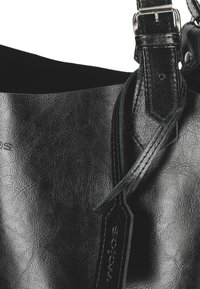 Borsa a tracolla in pelle nera con texture liscia, tracolla regolabile con hardware metallico e dettaglio del logo embossato.