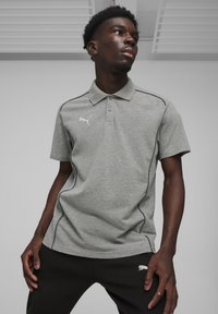 Grijze polo met kraag, korte mouwen en zwarte accentpiping. Bevat een klein wit logo op de linkerkant van de borst en een geribbelde textuur.