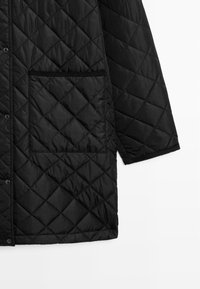 Schwarze gesteppte Oberbekleidung mit Druckknopfverschluss, einer Brusttasche und strukturiertem Stoff mit Rautenmuster.