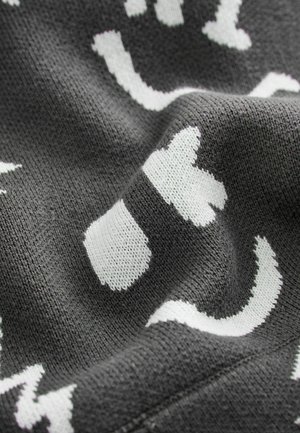 Šedá pletená tkanina s bílými abstraktními vzory koček a tlapek, s měkkým, texturovaným vzhledem a různou tloušťkou nitě.