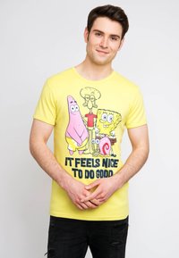 Yellow cotton T-shirt featuring cartoon characters: SpongeBob, Patrick, and Squidward, with the text "IT FEELS NICE TO DO GOOD" printed below.