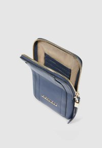 Portafoglio in pelle blu navy con chiusura lampo, interno in beige chiaro e scomparti per carte. Dettagli in metallo dorato lungo la cerniera.