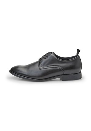Chaussure habillée en cuir noir avec un bout rond, un laçage et un petit talon. Texture lisse avec un minimum de coutures et une languette à l'arrière.