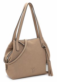 Beige perforated handbag with black trim, dual shoulder straps, and a side zipper pocket; includes a detachable tassel and logo detail.