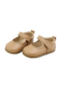 Zapatos Mary Jane de cuero color marrón claro con borde con ondas, una correa de Velcro, puntera redonda y suela flexible de color marrón claro.