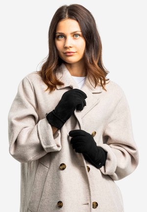 Light gray wool coat with large buttons, worn over a black shirt, complemented by black gloves. The fabric has a soft texture.