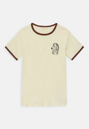 Kremowy t-shirt z krótkim rękawem, brązowym obszyciem i małą czarno-białą ilustracją głowy zebry na lewej piersi.