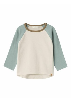 Koszulka dla malucha z długim rękawem, kremowym tułowiem, jasnoniebieskimi rękawami raglanowymi oraz brązową lamówką przy dekolcie.