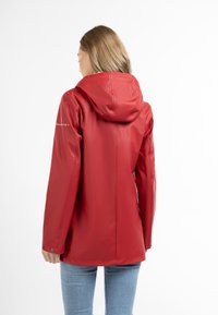 Rød vandtæt jakke med hætte, der har en glat tekstur og en tætsiddende pasform. Inkluderer trykknaplukninger ved ærmerne og et minimalistisk logo.