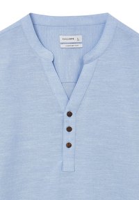 Himmelblaues Baumwollhemd mit Henley-Ausschnitt, drei braunen Knöpfen und einem bequemen Schnitt. Glatte Textur und dezente Stoffdetails.