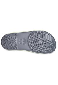 Semelle d'une chaussure Crocs verte montrant des motifs de bande de roulement détaillés, des indications de taille et le logo Crocs sur un fond blanc.