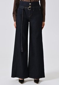 Brede donkerdenim broek met hoge taille, uitgerust met twee knopen, een riemlus met een metallic gesp en zichtbare stikseldetails.