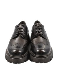 Scarpe brogue in pelle nera con perforazioni dettagliate, suola spessa e lacci, caratterizzate da una finitura lucida e un classico design a punta di ala.