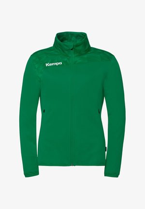 Grøn jakke med fuld lynlås, høj krave, lange ærmer, sidelommer, diskrete mønstrede skulderpaneler og "Kempa"-logo på venstre bryst.