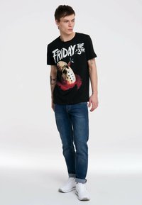 Black cotton t-shirt featuring a graphic print of a hockey mask and the text "Friday the 13th." Short sleeves, relaxed fit, and crew neck.