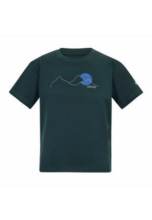 Blonder Junge steht mit den Händen in den Taschen, trägt ein dunkelblaues T-Shirt mit Grafik, dunkle Cargo-Shorts, helle Socken und schwarze Wanderschuhe.