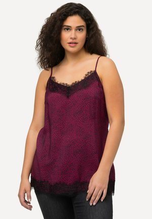 Camisole en satin fuchsia avec une dentelle noire au niveau du décolleté et de l'ourlet, dotée de bretelles spaghetti et d'une coupe décontractée. Motif à pois sur l'ensemble.