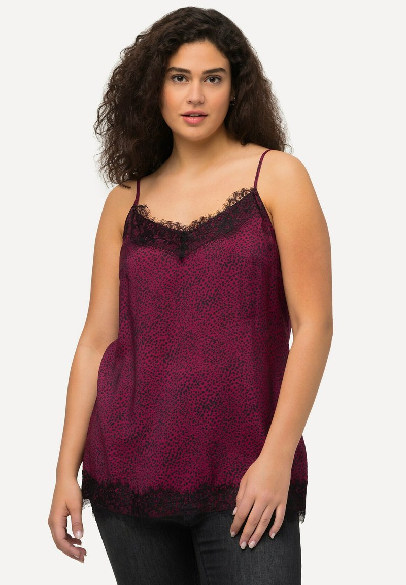 Camisola in satin fucsia con bordo in pizzo nero sul colletto e sull'orlo, dotata di spalline sottili e di una vestibilità rilassata. Motivo a pois su tutta la superficie.