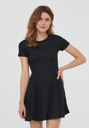 Czarna sukienka z krótkim rękawem o rozszerzającym się fasonie, prążkowanej fakturze, okrągłym dekolcie i szwach podkreślających kształt.