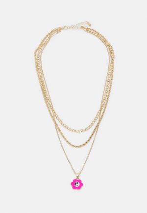 Colar dourado em camadas com três estilos de corrente: uma corrente plana, uma corrente torcida e uma corrente fina. Inclui um pendente em forma de flor rosa com detalhes de yin-yang.