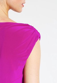 Fuksia mekko, jossa on kerätty olkapääyksityiskohta, sileä pinta ja vartalonmyötäinen siluetti, joka esittelee takakatselun.