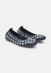 Musta nahkainen ballerina-kengät, joissa on hopeiset metallinapit ylhäällä, pyöreä kärki ja joustava pohja mukavuutta varten.