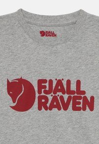 Pilkas medvilnės marškinėliai su ryškia raudona grafika, kuriame užrašyta "FJÄLL RÄVEN" ir stilizuotas lapės logotipas. Apvalus iškirpimas, trumpomis rankovėmis.