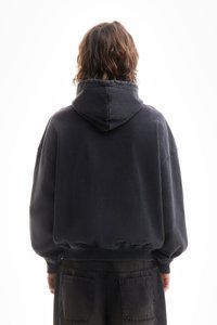 Moletom oversized de cor cinza escuro, com bolso canguru frontal, punhos canelados e capuz com cordão. Textura suave, design casual.