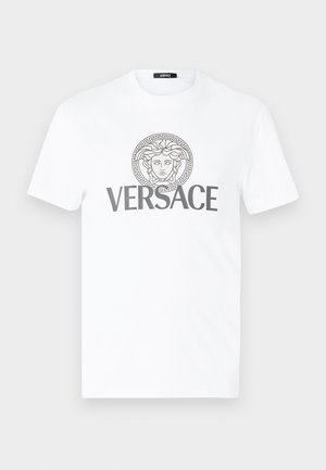 T-shirt en coton blanc avec un col rond, arborant un motif grec en gris et un emblème de Méduse imprimé au centre avec le texte "VERSACE" en dessous.