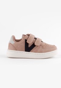 Baskets en suède rose clair avec des bandes Velcro, détail logo noir sur le côté et semelle en caoutchouc blanche. Talon renforcé avec accent gris.