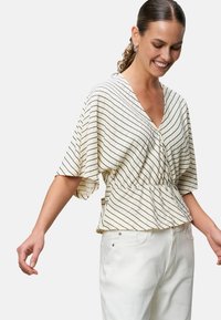 Cream blouse with black horizontal stripes, short sleeves, V-neck, and elastic waist gathered design. Paired with white pants.