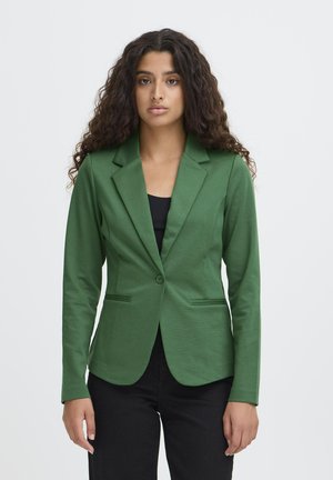 Blazer verde con un corte entallado, solapas cortadas, cierre de un solo botón y dos bolsillos frontales. Fabricado en tejido texturizado.