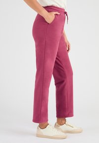 Fleece joggingbroeken in een diepe roze kleur, met een elastische tailleband, trekkoord, zijzakken en een relaxte pasvorm.