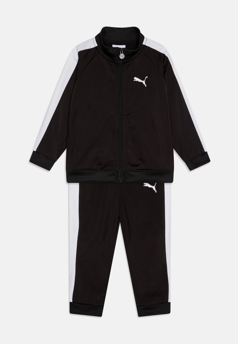 Survêtement de sport noir comprenant une veste zippée avec des empiècements latéraux blancs et un pantalon assorti. Fabriqué en tissu lisse avec un accent de logo.