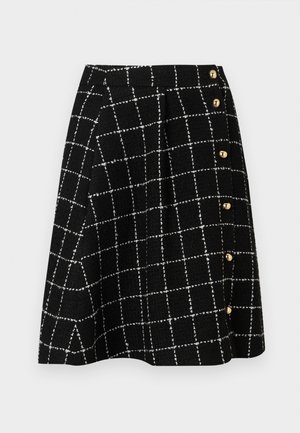 Falda de tweed negra con un patrón de cuadrícula blanca, diseño acampanado y acentos de botones dorados en el costado.