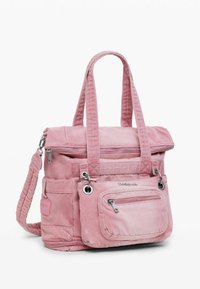Mochila de lona rosa con doble asa, cierres con cremallera, bolsillo frontal y correa trenzada para el hombro; cuenta con detalles de herrajes plateados.
