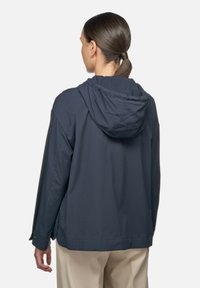 Marineblauwe hooded jack met een ontspannen snit, voorkant naden en een soepele textuur. Voorzien van een trekkoord in de capuchon en een rechte zoom.
