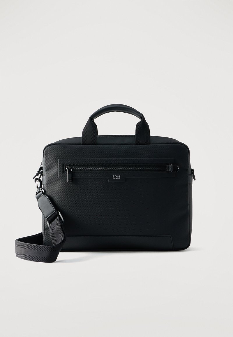 Μαύρη ορθογώνια τσάντα με χειρολαβές στην κορυφή, μπροστινή τσέπη με φερμουάρ, ρυθμιζόμενο ιμάντα ώμου και λογότυπο "BOSS" στον μπροστινό πίνακα.