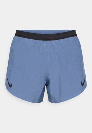 Shorts deportivos de color azul claro con cinturilla elástica negra, que presentan un logo negro de Nike en el lado izquierdo y están hechos de una tela lisa y ligera.