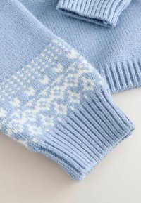 Hellblau gestrickte Pulloverwärmer mit weißen geometrischen und floralen Mustern, ausgestattet mit gerippten Bündchen auf einem neutralen Hintergrund.