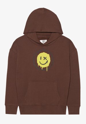Brun hættetrøje med gul dryppende smiley, hvor det ene øje er krydset ud, og omgivet af motiverende tekst.