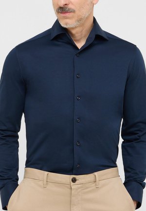 Navyblaues Langarmhemd mit Knopfverschluss, aus glattem Stoff gefertigt, mit modernem Kragen und dezenten Nähdetails.