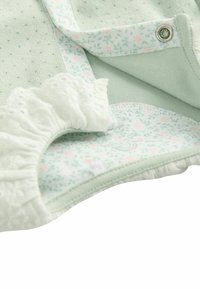 Bomuldsbabydragt i mintgrøn, med en tekstureret overflade og blomstertrykt for. Pyntet med blondekant og trykknapper.