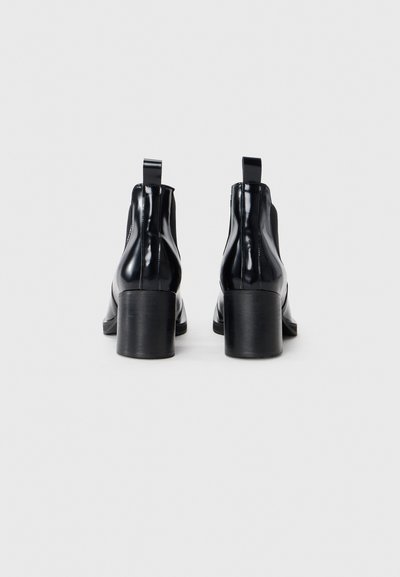 Black patent leather ankle boots with a rounded toe, smooth texture, mid-height block heels, and pull tabs at the back for easy wear.