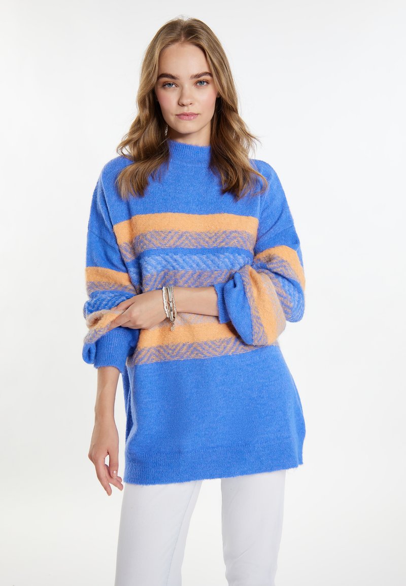 Maglione azzurro a maglia con righe orizzontali arancioni e crema, caratterizzato da un collo alto e maniche ampie e arrotolate.
